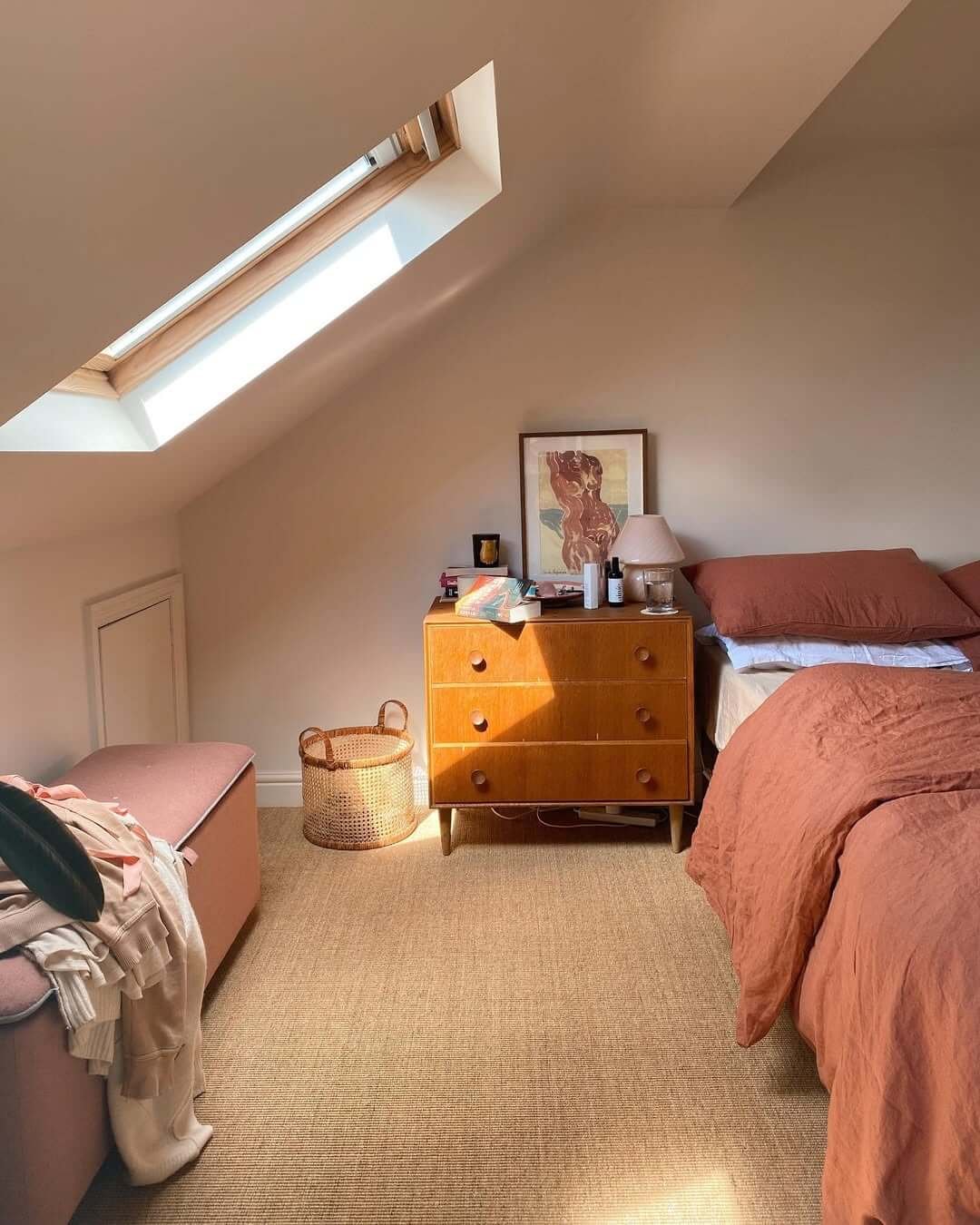 Soft rust bedding enhances light walls for inviting charm