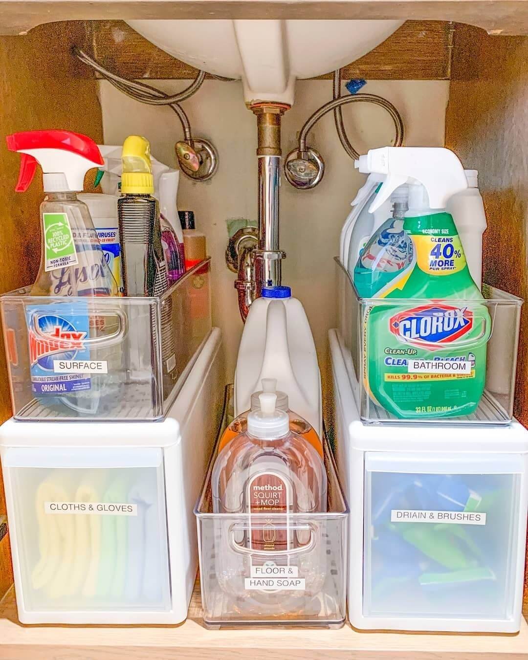Organized cleaning supplies with clear bins and labels